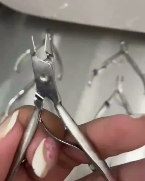 Alicate de cutícula sendo conferido na mão