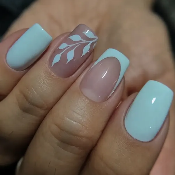 Unhas curtas em azul claro com folhas desenhadas à mão e francesinha